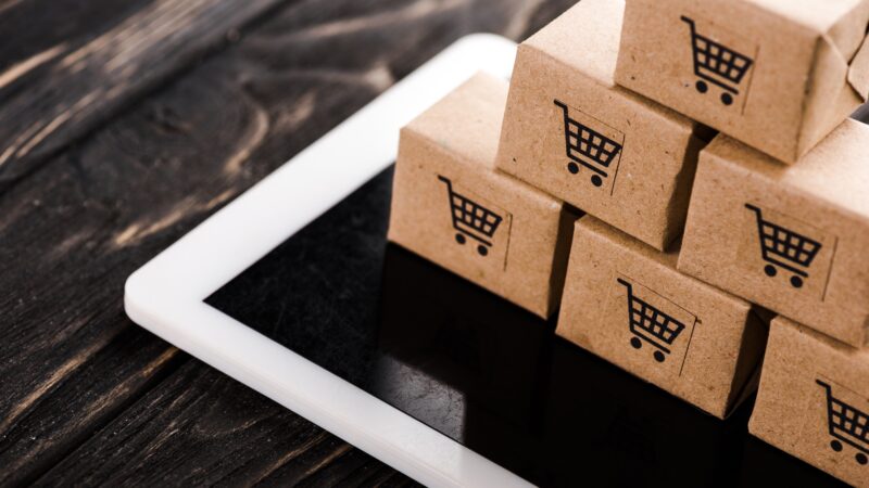 selective focus of small carton boxes on digital tablet, e-commerce concept